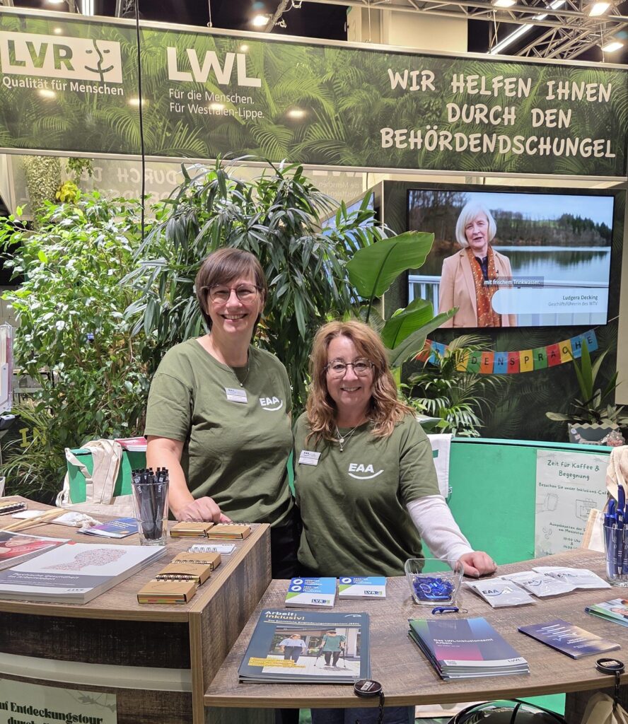 Zwei Fachberaterinnen der EAA Rheinland stehen am Beratungsthresen des Messestands.